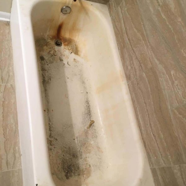 Newly installed tile with a worn and rusted bathtub before refinishing in Naperville, IL.