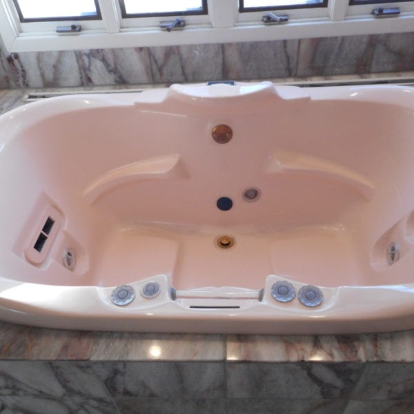 Powder pink whirlpool tub before refinishing in Burr Ridge, IL.